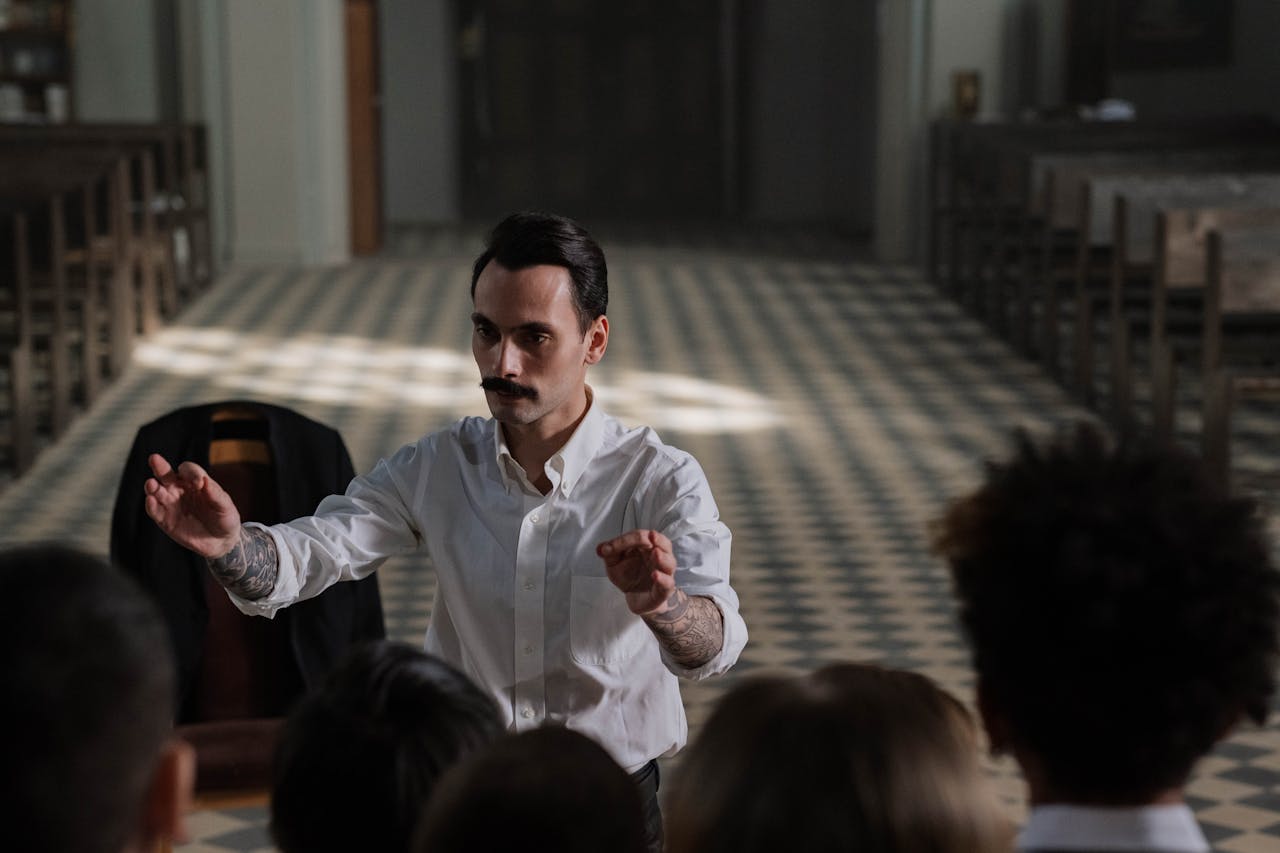 Man conducting choir inside a church, focusing on vocal training and performance art.